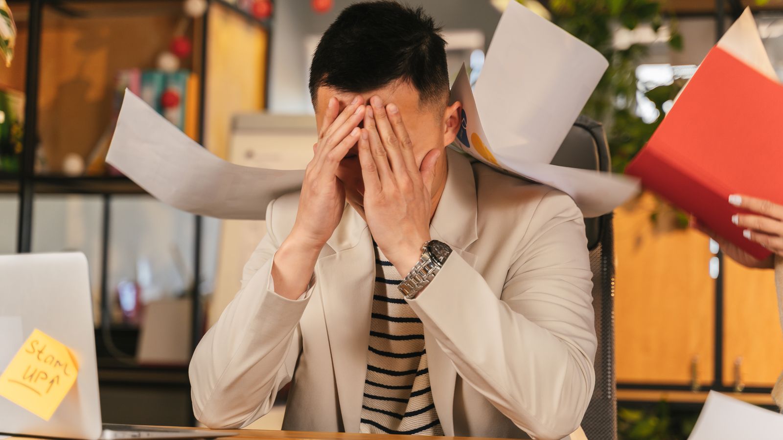 Office worker overwhelmed by paperwork and interruptions