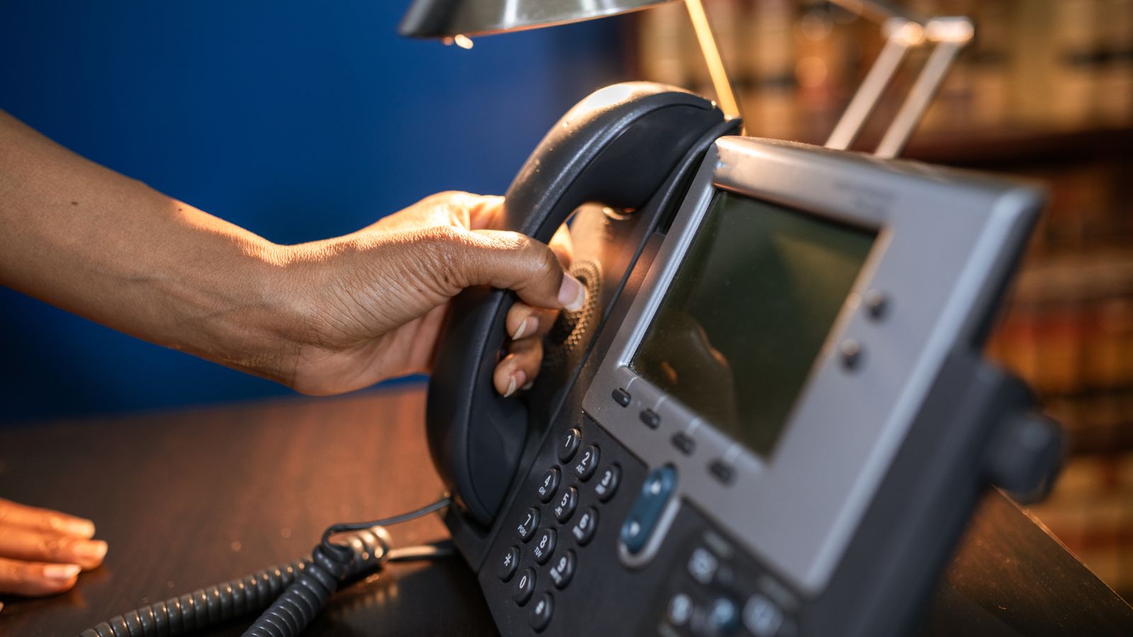 Hand answering an office desk phone